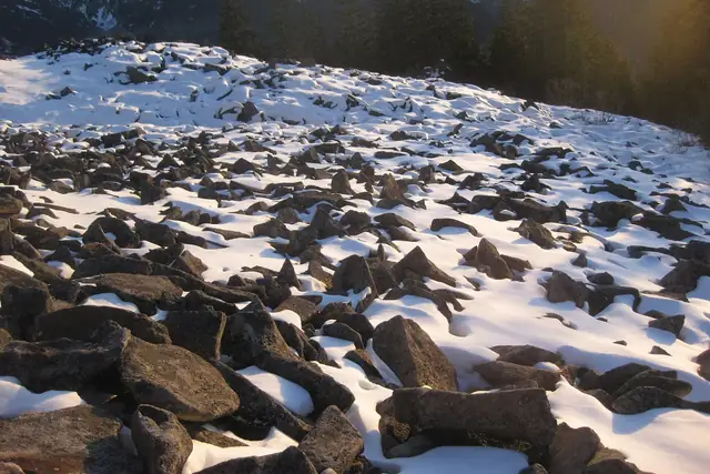 Snow-dusted talus near the top of Mailbox Peak at golden hour in winter