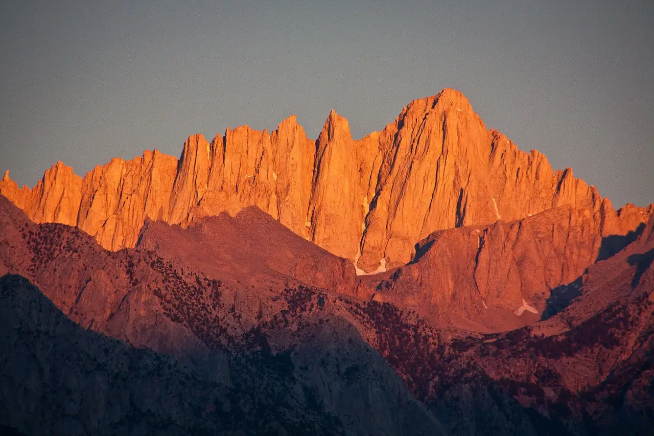 Mt. Whitney and the needles in orange sunrise light from Lone Pine in August
