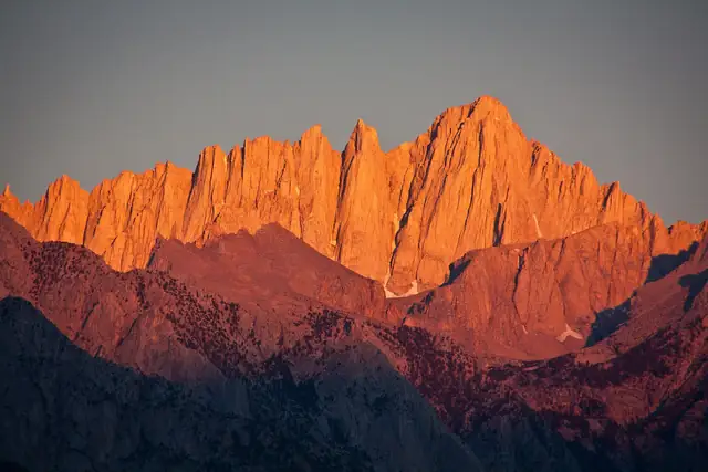 Mt. Whitney and the needles in orange sunrise light from Lone Pine in August