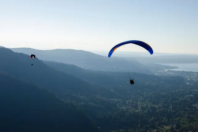 A paraglider launched from Poo Poo Point floating above Issaquah