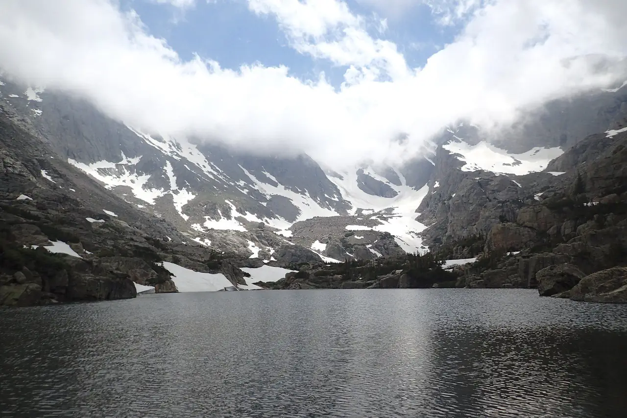 Lake of Glass below cloud-wrapped peaks in late June, just before Sky Pond