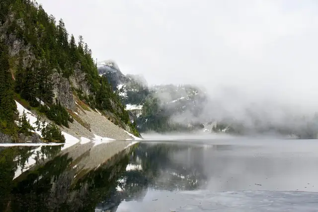 Fog lifting off a still-icy Snow Lake in late June