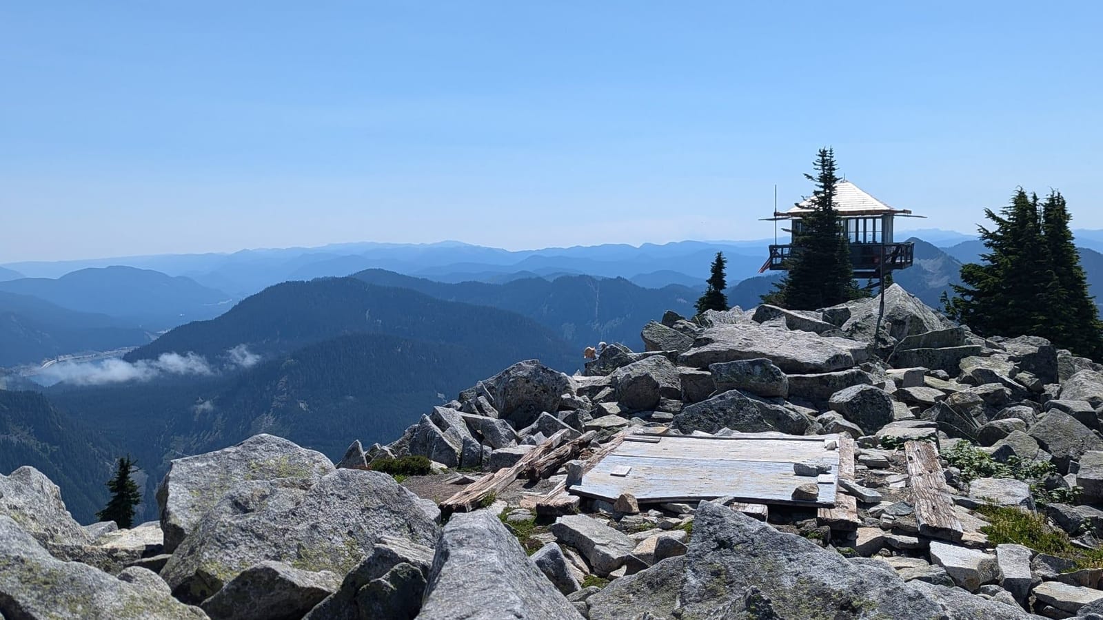 The Granite Mountain fire lookout perched on a summit of jumbled granite boulders above hazy ridges