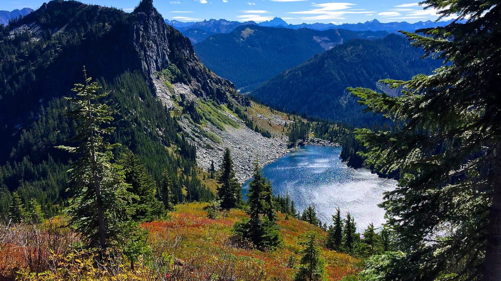 Lichtenberg Mountain and Lake Valhalla seen from the slopes of Mount McCausland, with red and orange fall color in the foreground