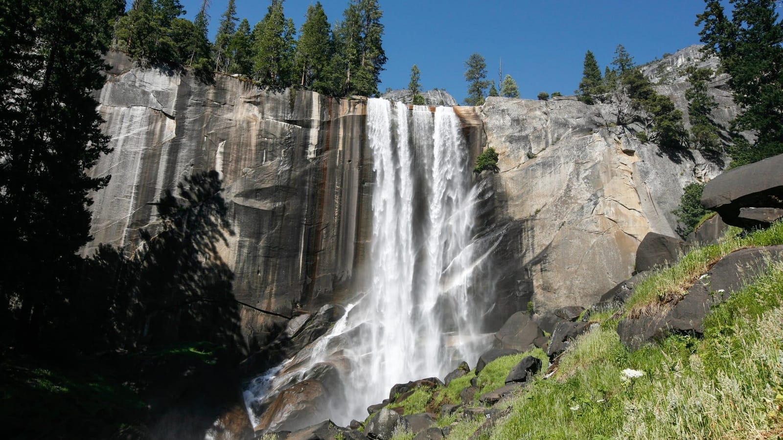 Vernal Fall dropping over a granite cliff beside the Mist Trail steps