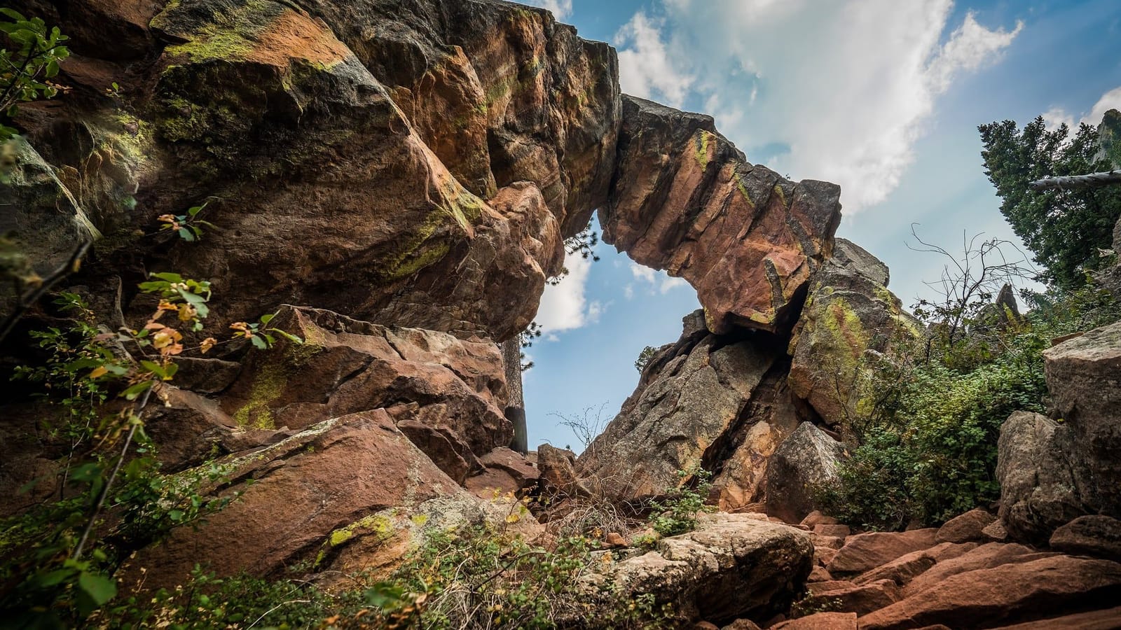 The sandstone span of Royal Arch framing blue sky above Boulder